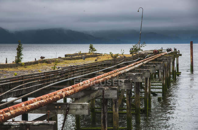 An Old Pier Extending Into The Columbia River; Astoria, Oregon, Estados Unidos de América - foto de stock