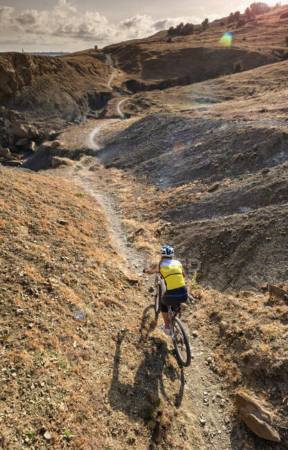 Frau fährt Mountainbike auf robustem Pfad; Tarifa, Cadiz, Andalusien, Spanien — Stockfoto