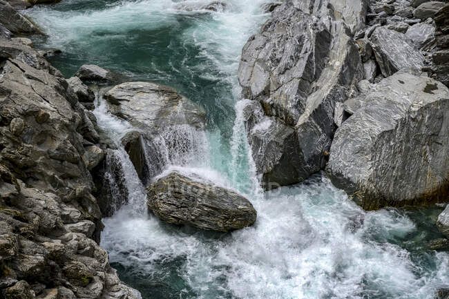Cascadas de agua azul sobre rocas en un río apresurado, Haast Pass, Mount Aspiring National Park, Isla Sur; Región de la Costa Oeste, Nueva Zelanda - foto de stock
