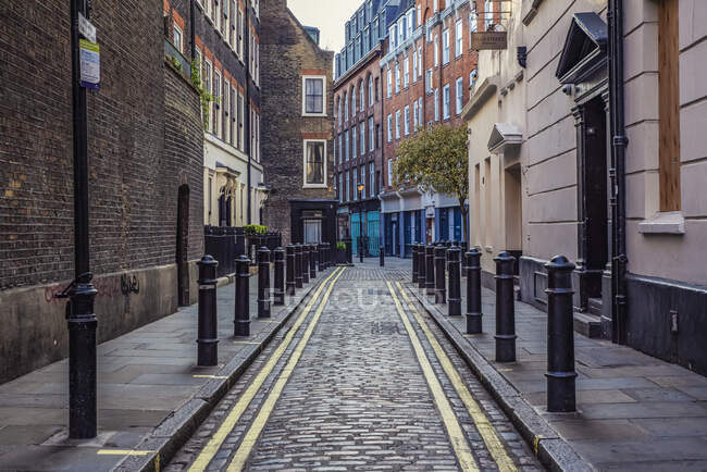 Cobblestone lane in Soho at evening rush hour during the national lockdown for the Covid-19 pandemic; London, England, UK — Stock Photo
