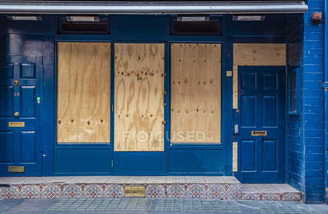 Windows boarded up on a building during national lockdown in London during the Covid-19 Global Pandemic; London, England — Stock Photo