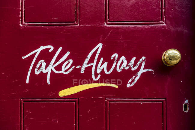 Распишитесь за еду на вынос на красной двери во время национальной изоляции, Covid-19 Global Pandemic; Лондон, Англия — стоковое фото