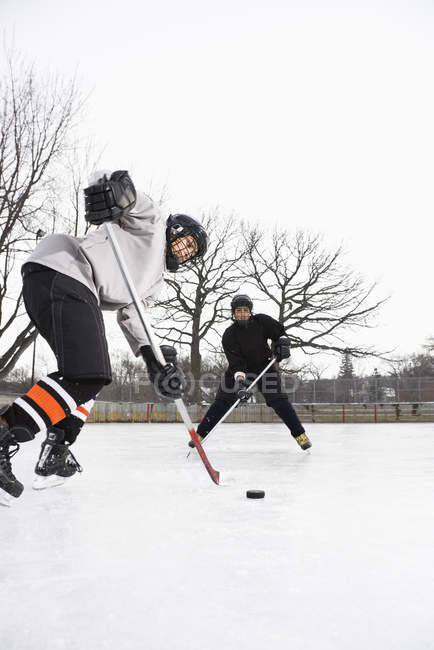 Rapazes a jogar hóquei no gelo . — Fotografia de Stock