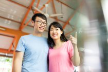 LIBRE Heureux couple asiatique étreignant ensemble, femme pointant — Photo de stock