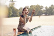 Young beautiful asian woman splashing water by pool — Stock Photo