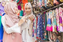 Two muslim girls in fabrics shop — Stock Photo