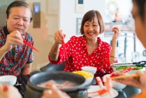 Glückliche asiatische Familie beim gemeinsamen Essen am Tisch — Stockfoto