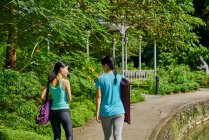 РЕЛИЗ Две женщины, идущие на йогу в ботанический сад, Сингапур — стоковое фото