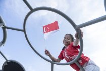 Ritratto di orgoglioso ragazzo di Singapore con bandiera nazionale — Foto stock