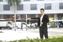Uomo d'affari che segnala taxi sulla strada della città — Foto stock