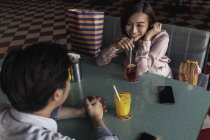 Young asian couple spending time together in bar with drinks — Stock Photo