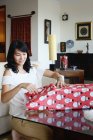 Asiático familia celebrando navidad día de fiesta, mujer embalaje regalo - foto de stock