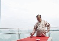 Старый азиат рисует иероглифы каллиграфии на китайском новом году — стоковое фото