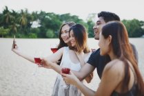 Jóvenes asiático amigos tomando selfie con bebidas - foto de stock