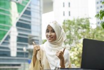 Young woman in a Tudung giving the thumbs up — Stock Photo