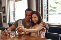 Jovem asiático casal fazendo selfie no restaurante — Fotografia de Stock