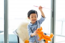 Lindo asiático chico jugando con juguetes - foto de stock