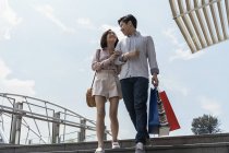 Jovem asiático casal andando juntos em escadas — Fotografia de Stock