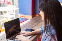 Atraente asiático mulher usando laptop dispositivo no café — Fotografia de Stock