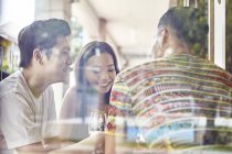 Young asian friends behind window together in bar — Stock Photo