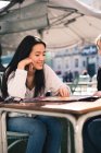 Beautiful friends looking a map in the streets of Spain sitting in a cafeteria — Stock Photo
