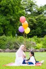 Mãe e criança com balões no parque . — Fotografia de Stock