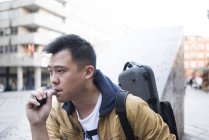 Giovane musicista asiatico maschio con violino e vaporizzatore in città — Foto stock