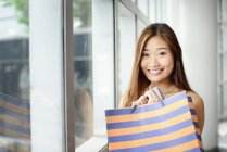 Young asian woman in shopping mall looking at camera — Stock Photo
