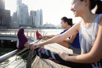Tow young asian women stretching outdoors — Stock Photo
