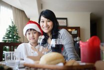 Азіатська сім'я святкує Різдво, мати з хлопчиком за столом — стокове фото