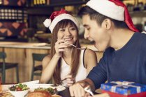 Couple of young asian friends together eating at christmas table — Stock Photo