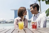 Young asian couple spending time together with drinks in Singapore — Stock Photo