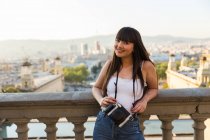 Beautiful young eurasian woman with camera in Barcelona — Stock Photo