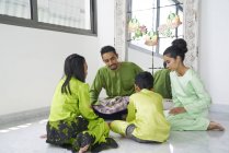 Joven asiático familia celebrando hari raya juntos en casa - foto de stock