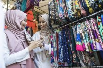 Due signore musulmane che fanno shopping per hijab . — Foto stock