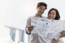 Jeune asiatique couple partage carte ensemble — Photo de stock