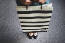 Recortado imagen de joven asiático mujer en centro comercial con bolsa - foto de stock