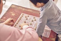 Счастливая азиатская семья проводит время вместе и играет в настольную игру — стоковое фото