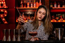 Ritratto di giovane barman donna che fa cocktail nel bar — Foto stock