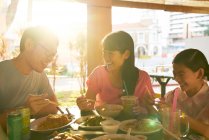 Felice giovane famiglia asiatica mangiare insieme in caffè — Foto stock