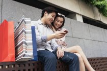 Giovane coppia asiatica trascorrere del tempo insieme con smartphone — Foto stock
