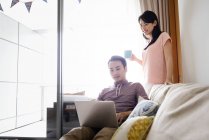 Mature asian casual couple using laptop together — Stock Photo