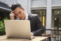Jovem asiático bem sucedido homem de negócios usando laptop — Fotografia de Stock