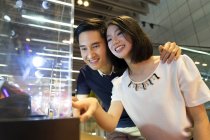 Young attractive asian couple together at shopping — Stock Photo