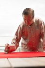 Vieil homme asiatique dessin calligraphie hiéroglyphes au Nouvel An chinois — Photo de stock