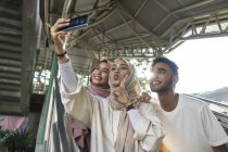 Group of happy muslim friends taking selfie on smartphone — Stock Photo