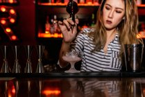 Retrato de jovem barman feminino fazendo coquetel no bar — Fotografia de Stock