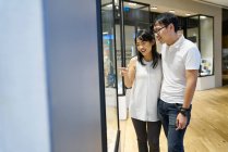RELEASES Glückliche junge asiatische Familie zeigt auf Einkaufszentrum — Stockfoto
