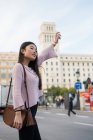 Young Chinese tourist woman flagging a cab — Stock Photo