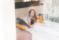 Chinesische junge und schöne Frau wacht morgens auf und frühstückt im Bett — Stockfoto